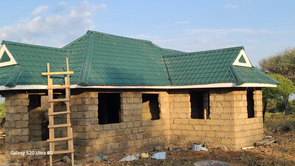 Green tile-profile roof with white fascia and gables